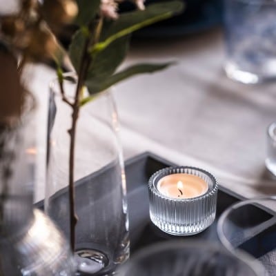 fyrfadsstage klart glas på bord med vase
